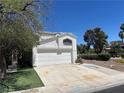 This is a two-story white home featuring a two-car garage and traditional desert landscaping in the front yard at 3929 Dream St, Las Vegas, NV 89108