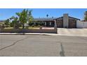 Charming single story home featuring desert landscaping, stone chimney, and long driveway at 4823 El Tesoro Ave, Las Vegas, NV 89121