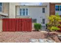 Townhome backyard featuring a red fence, rock landscaping, and greenery at 572 Tam O Shanter, Las Vegas, NV 89109