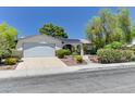 Inviting single-story home featuring mature landscaping, a two-car garage, and solar panels at 7100 Carrondale Way, Las Vegas, NV 89128