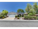 Inviting single-story home featuring mature landscaping, a two-car garage, and solar panels at 7100 Carrondale Way, Las Vegas, NV 89128