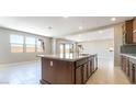 Open-concept kitchen with a large island, tiled floors, modern appliances, and lots of natural light at 769 Cloud Creek St, Henderson, NV 89011