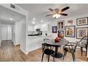 Well-lit dining area with a modern ceiling fan, complemented by an open kitchen design and unique wall art at 7950 W Flamingo Rd # 1042, Las Vegas, NV 89147