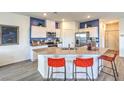 Modern kitchen featuring white cabinets, stainless steel appliances, and breakfast bar seating at 7965 Aurora Sky St # 623, North Las Vegas, NV 89084