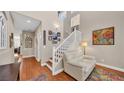 Bright foyer featuring wood floors, high ceilings, a staircase, and a cozy seating area with a white leather sofa at 8139 Skytop Ledge Ave, Las Vegas, NV 89178