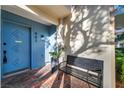 Close up of stylish home entry with blue door, modern bench, and red brick at 882 Tam O Shanter, Las Vegas, NV 89109