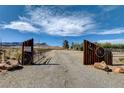 Private property entrance featuring custom wooden gate with wagon wheel accents and desert landscape at 12992 State Hwy 160, Las Vegas, NV 89161