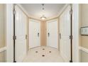 Inviting hallway featuring four white paneled doors and neutral tile flooring with decorative accents at 135 E Harmon Ave # 2702, Las Vegas, NV 89109