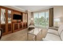 Comfortable living room with light-colored furniture, a large window view, and custom built-in storage at 135 E Harmon Ave # 2702, Las Vegas, NV 89109