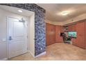 Inviting entryway featuring a tiled floor, storage cabinet, and a stylish brick accent wall at 200 W Sahara Ave # 2210, Las Vegas, NV 89102