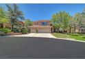 Charming two-story home with a three-car garage, desert landscaping, and a well-maintained lawn at 229 N Buteo Woods Ln, Las Vegas, NV 89144