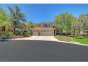 Charming two-story home with a three-car garage, desert landscaping, and a well-maintained lawn at 229 N Buteo Woods Ln, Las Vegas, NV 89144