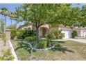 Beautiful home with a well-manicured lawn and mature trees providing shade at 2528 Huber Heights Dr, Las Vegas, NV 89128