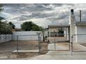 Image of the front yard behind a chain link fence and a partial view of a single-story home at 2645 Cedar Ave, Las Vegas, NV 89101