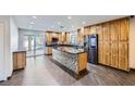 Large kitchen featuring a center island, modern appliances, wood cabinets, tile floors, and sliding glass door at 3557 Wayne Cir, Las Vegas, NV 89121