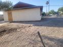 Shows the side exterior of the home with beige walls and a chain link fence at 4430 Judson Ave, Las Vegas, NV 89115