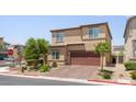 Tan two-story home with a brick driveway and landscaping at 4498 Lantern Point Ave, North Las Vegas, NV 89084