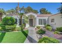 Inviting front entrance with a walkway, lush landscaping, and a charming covered porch, perfect for curb appeal at 5224 Painted Lakes Way, Las Vegas, NV 89149