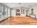 Spacious living area featuring hardwood floors, custom built-ins, and a cozy fireplace with mantel at 5224 Painted Lakes Way, Las Vegas, NV 89149