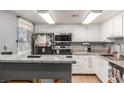 Bright kitchen with white cabinetry, sleek appliances, and ample countertop space at 5301 River Glen Dr # 205, Las Vegas, NV 89103