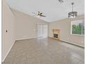 Open living room with a fireplace, ceiling fan, and sliding door at 5820 Royal Castle Ln, Las Vegas, NV 89130