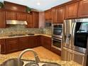 Gourmet kitchen with granite countertops, stainless steel appliances, and custom cabinetry at 585 Via Alhambra, Las Vegas, NV 89123
