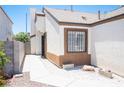 Side entrance of a cozy single-story home featuring a concrete walkway and desert landscaping at 7231 Sequoia Springs Dr, Las Vegas, NV 89147