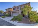 Desert landscaped two-story home with a two-car garage, a covered front porch, and neutral paint at 7605 Lake Fork Peak St, Las Vegas, NV 89166