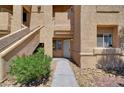 Exterior building view showcasing stucco walls, desert landscaping, and an open entryway at 900 Heavenly Hills Ct # 114, Las Vegas, NV 89145