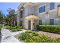 Inviting condo exterior featuring a covered entrance, well-kept landscaping, and a sidewalk at 9050 W Warm Springs Rd # 2062, Las Vegas, NV 89148