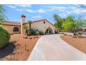 Beautiful home featuring desert landscaping, mature trees, and a circular driveway at 9385 Mohawk St, Las Vegas, NV 89139