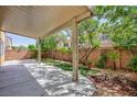 Spacious backyard features a covered patio, artificial turf, and mature trees at 9814 Gifthouse St, Las Vegas, NV 89178