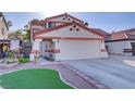 Charming home featuring a two-car garage, tile roof, desert landscaping, and a private courtyard entrance at 117 Lotus Blossom Ct, Las Vegas, NV 89145