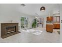 Open-concept living room with fireplace, sliding glass doors, and adjacent kitchen at 117 Lotus Blossom Ct, Las Vegas, NV 89145