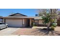 Charming single-story home featuring a two-car garage, mature tree, and desert landscaping at 1886 Ludington Ave, Las Vegas, NV 89156