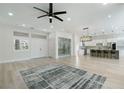 Bright, open-concept living room featuring modern flooring, a wine cellar, and leading into the kitchen at 2755 Darby Falls Dr, Las Vegas, NV 89134