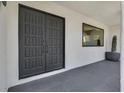 Modern home entrance featuring double doors, a sleek window, and a stylish potted cactus at 324 Park Way East, Las Vegas, NV 89106