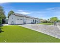 Stylish home featuring a large driveway, manicured lawn, and a three-car garage, exuding modern elegance at 324 Park Way, Las Vegas, NV 89106