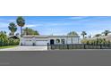 Beautiful single-story home boasts a well-manicured front yard, an iron fence, three-car garage, and a modern design at 324 Park Way, Las Vegas, NV 89106
