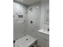Modern bathroom featuring a marble tiled shower with a built-in shelf and updated fixtures at 335 W Basic Rd, Henderson, NV 89015