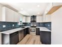 Charming kitchen with white countertops, black cabinetry, tile backsplash, and stainless steel appliances at 5004 Celebrity Cir, Las Vegas, NV 89119