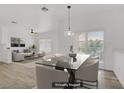 Bright dining area open to living room features modern light fixture and sliding glass door at 5112 Harvest Time St # 201, Las Vegas, NV 89130