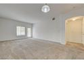 Spacious carpeted living room featuring neutral walls, large windows, and access to the entry hall at 6160 Rumrill St # 202, Las Vegas, NV 89113