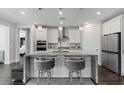 Bright kitchen with white cabinets, stainless appliances, pendant lights and large island at 64 Lake Oasis St, Henderson, NV 89011