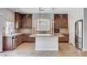 Spacious kitchen with a large island, dark wood cabinets, stainless steel appliances, and natural lighting at 6564 Baroque Ave, Las Vegas, NV 89139