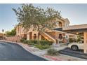 Condo exterior featuring lush landscaping, covered parking, and a well-maintained facade under a sunny sky at 830 Carnegie St # 512, Henderson, NV 89052