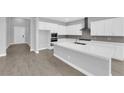 Bright kitchen features white cabinets, stainless appliances, an island and modern countertops at 851 Klamath Springs St, Henderson, NV 89011