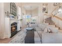 Bright living room with fireplace, soaring ceilings, large windows, and a staircase at 8605 Trianon Ln, Las Vegas, NV 89145