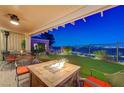 Inviting covered patio with fire pit and comfortable seating offering stunning city views at 10621 Tinta Ln, Las Vegas, NV 89144