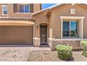 Close-up of this home's entrance, including the garage, a trimmed walkway, and stone veneer accents at 10961 Winter Rise St, Las Vegas, NV 89141